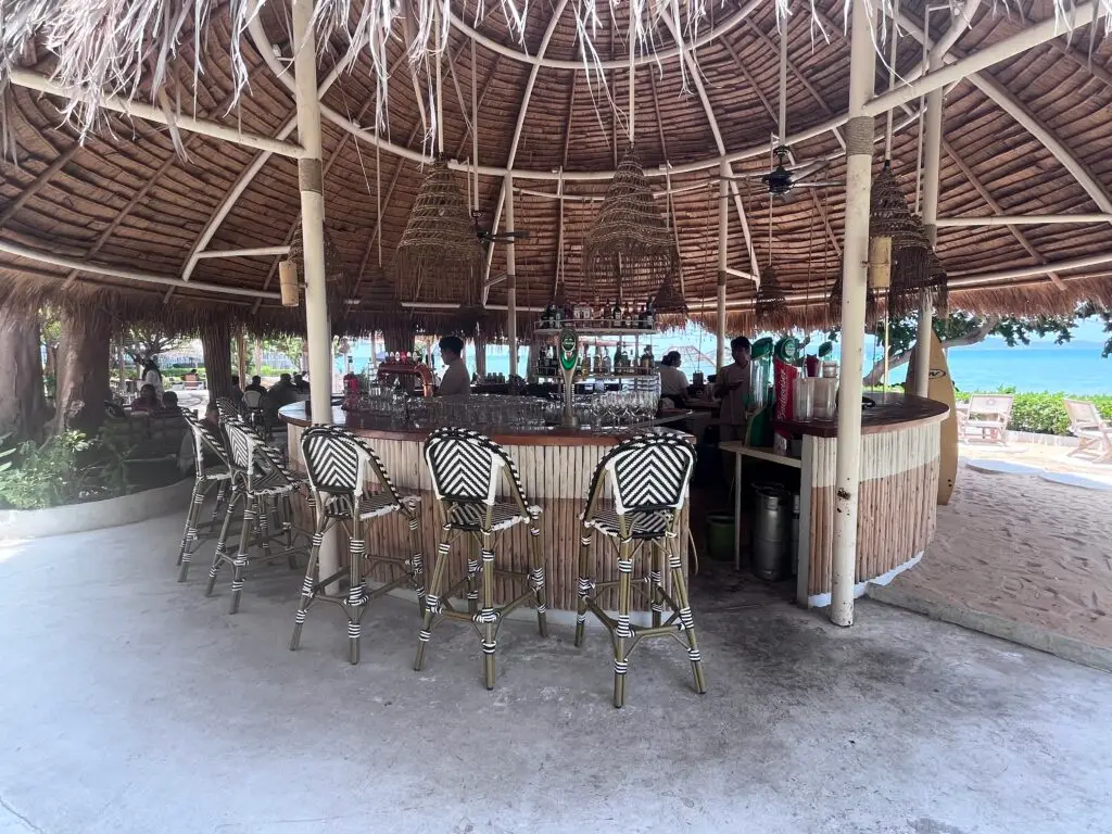The bar area at The Oxygen Beachside Oasis in Pattaya, featuring straw-roofed canopies and ocean views