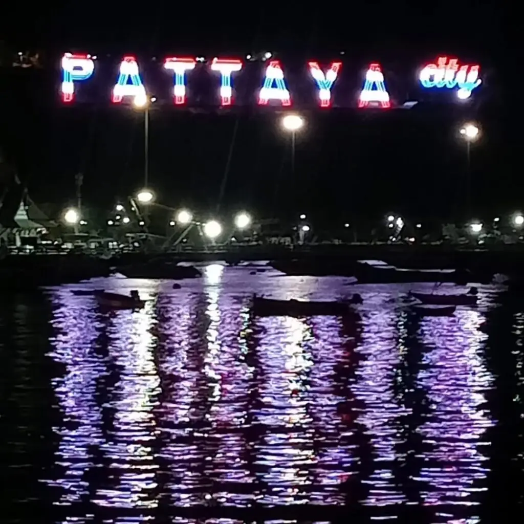 The new Pattaya City sign at night with its reflection on the sea